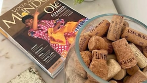 A magazine titled "Volta ao Mundo" next to a glass jar filled with corks. - Galagana Charm House (Golega)