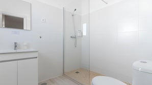 A modern bathroom with a shower, toilet, and sink. - Galagana Charm House (Golega)