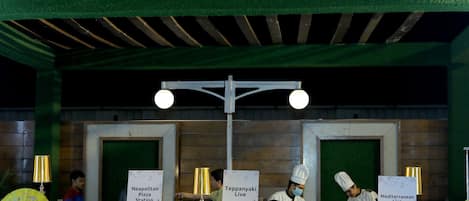 Un espace où l’on peut déguster différents plats, avec des présentoirs indiquant les spécialités suivantes : pizzas napolitaines, cuisine japonaise teppanyaki et cuisine méditerranéenne.