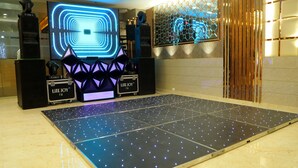 Une piste de danse moderne dotée d’un éclairage à LED, d’un grand écran lumineux et d’enceintes à la marque de l’établissement.
