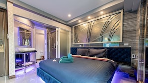 Een moderne slaapkamer met een groot bed, een inbouwkapsalon en een grote spiegel.