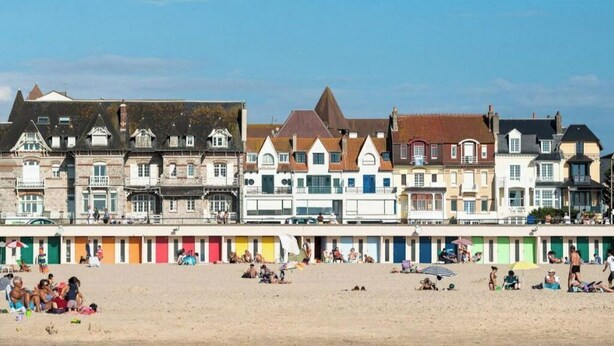 A beachside promenade with colorful beach huts and a row of historic buildings. - Touquettoise 'Romeo (Paris)