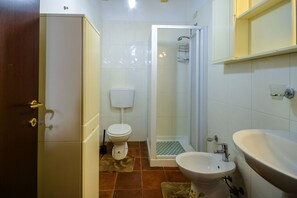 Een douche, een haardroger, een bidet, handdoeken