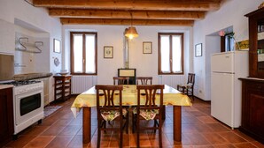 Eine Küche mit Esstisch, Stühlen, Herd und Kühlschrank.
