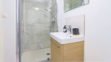 Een douche, een haardroger, handdoeken, toiletpapier