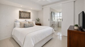 Une chambre à coucher moderne avec un grand lit, un téléviseur à écran plat et un élément décoratif mural.