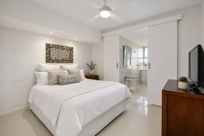 A modern bedroom with a large bed, a flat-screen TV, and a decorative wall piece. - Horizon View Retreat by Ready Set Stay - Beach Views (Sorrento)