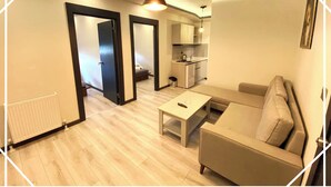 Una sala de estar moderna con un sofá, una mesa de centro y una cocina al fondo.
