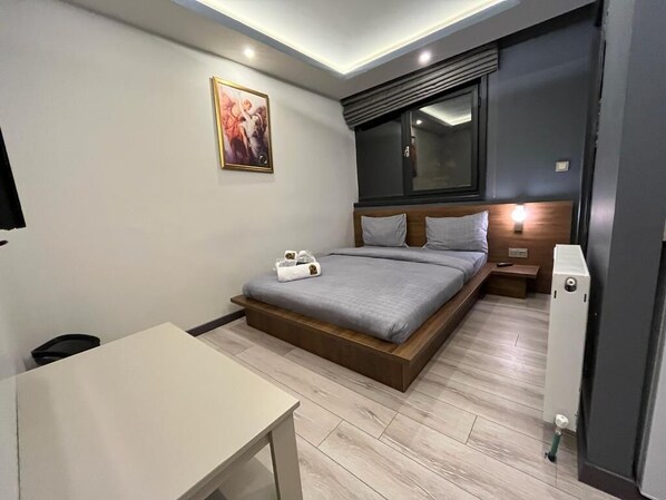 Un dormitorio moderno con cama, mesita de noche y un cuadro en la pared.