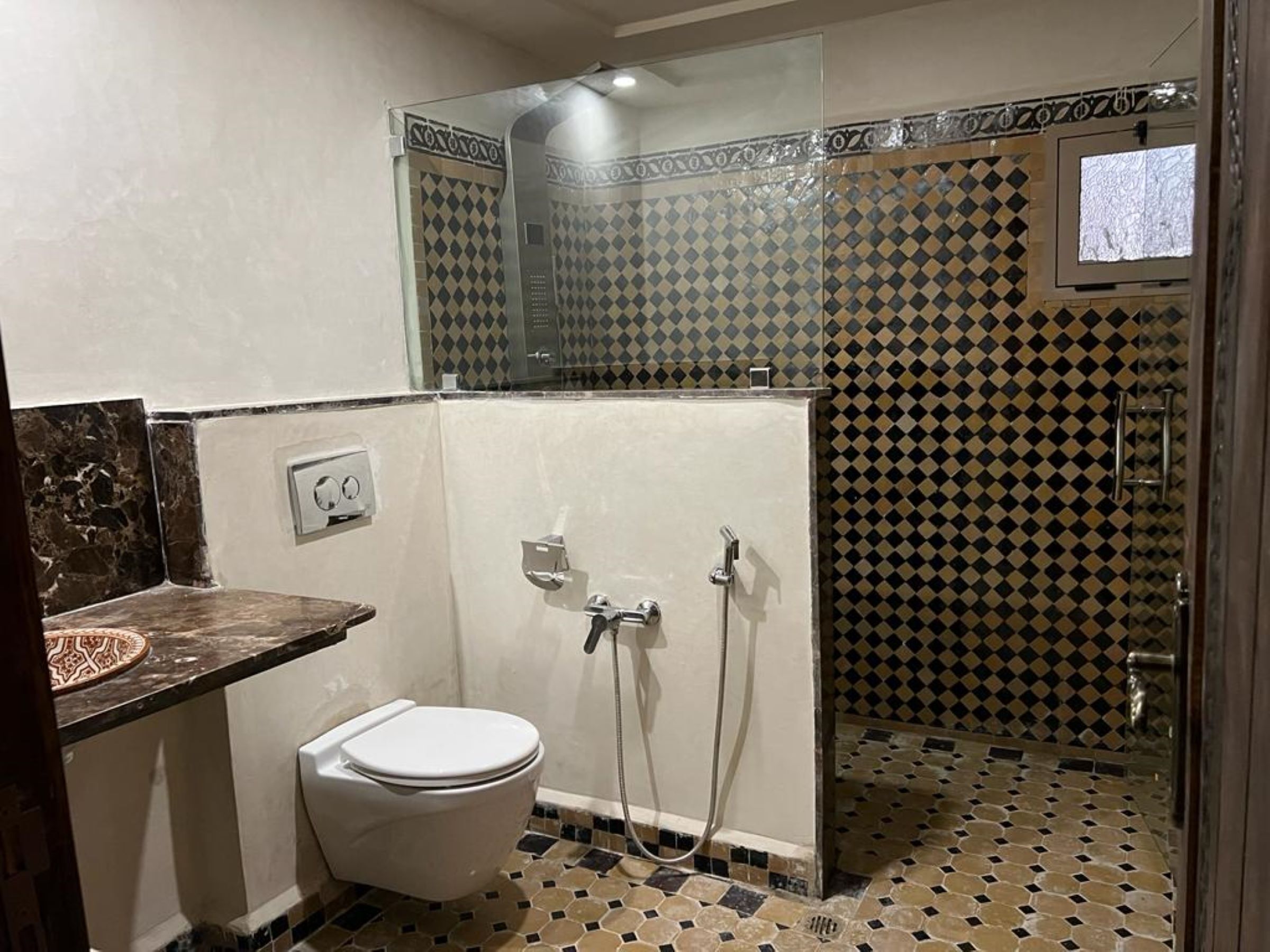 A bathroom with a toilet, a shower, and a sink.