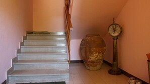 A staircase with a handrail, a large ceramic pot, and a clock on the wall. - Nar Apartment A4 1 - With sea View (Pasman)
