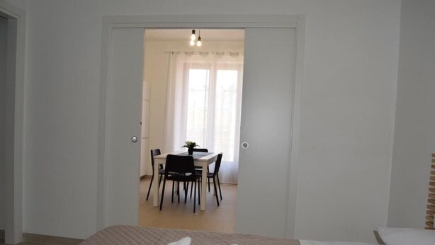 Une chambre avec un lit, un bureau et une chaise au fond.