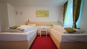 A hotel room with two beds, a small bedside table, a nightstand, and a wall-mounted artwork. - Room in Guest Room - Pension Forelle - Double Room (Forbach)