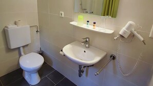 A bathroom with a toilet, sink, and shower. - Room in Guest Room - Pension Forelle - Double Room (Forbach)
