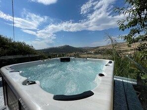 Un bain à remous offrant une vue dégagée sur un paysage montagneux en arrière-plan.