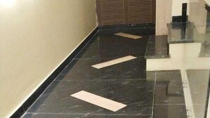 A polished black marble floor with white geometric patterns, a glass railing, and a beige wall with a textured pattern. - Culture by BVH Hospitality Greater Noida (Greater Noida)