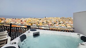 Une terrasse sur le toit, dotée d’un jacuzzi et offrant une vue sur une zone urbaine densément peuplée.