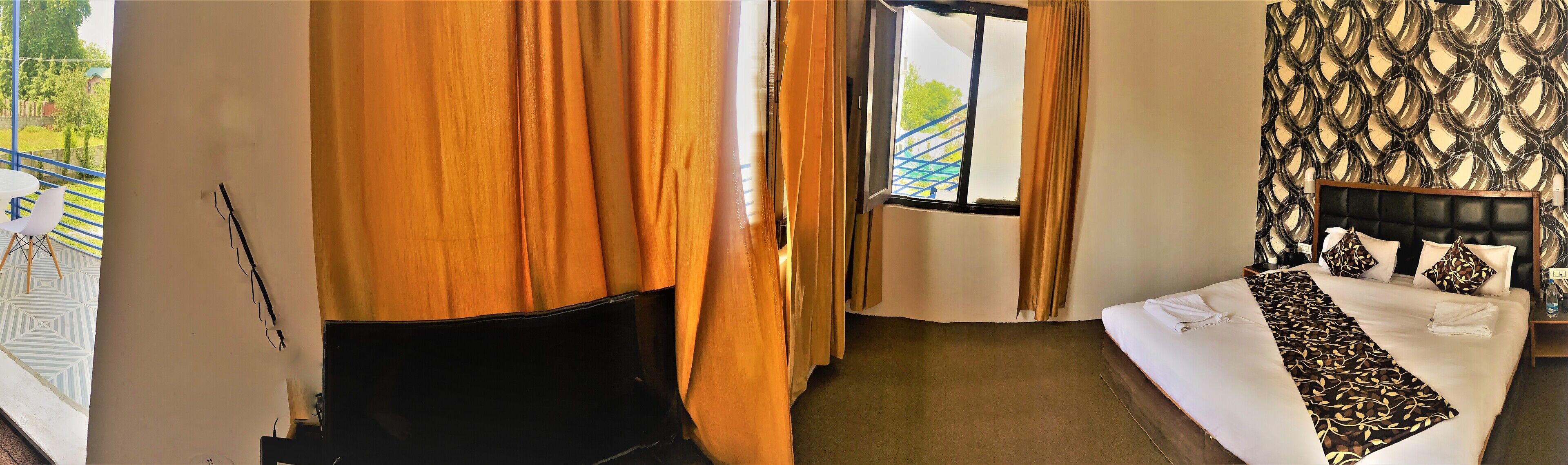 A hotel room with a bed, a window, a curtain, and a view of the outside.