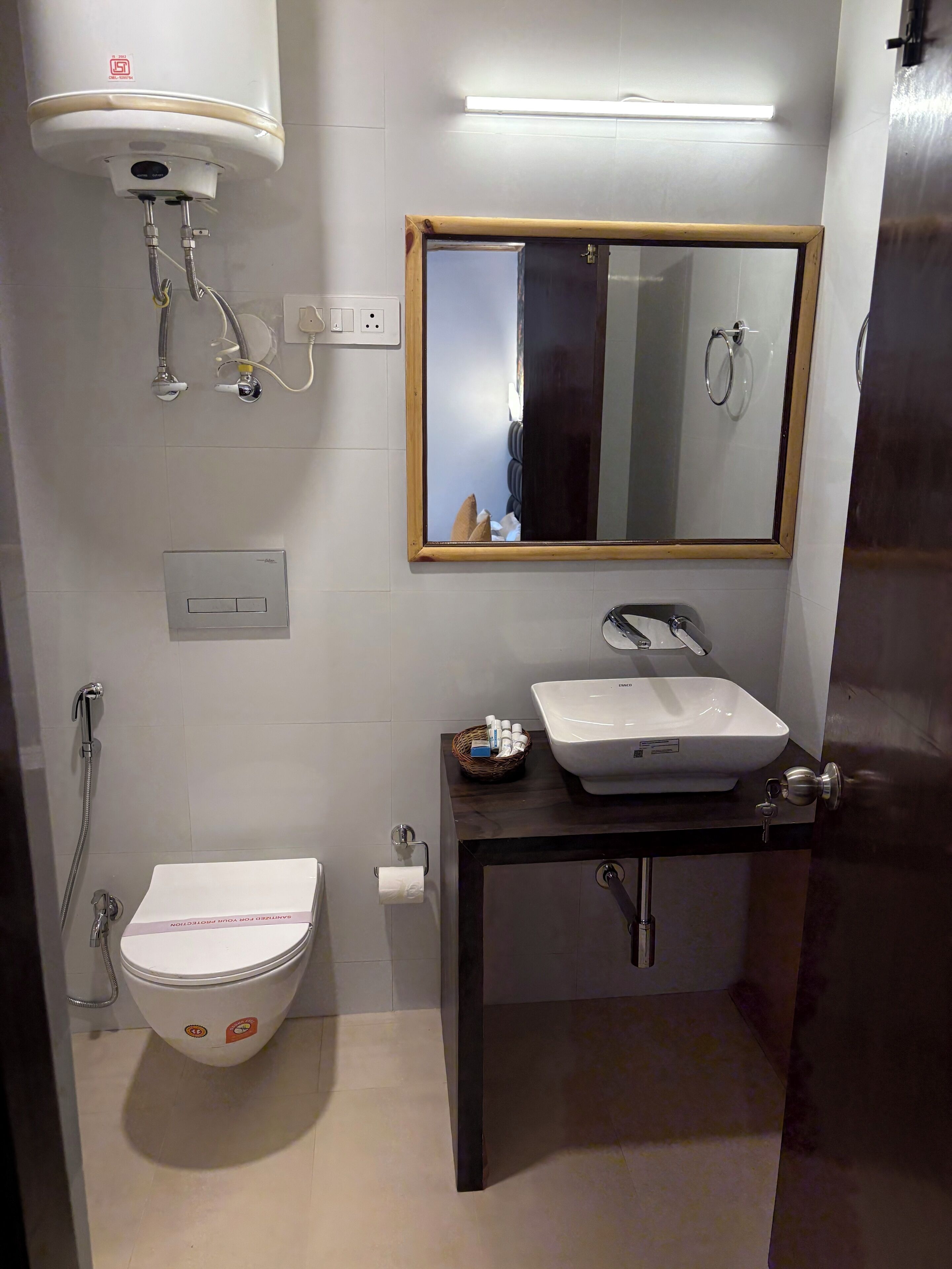 A bathroom with a toilet, a sink, a mirror, and a shower.