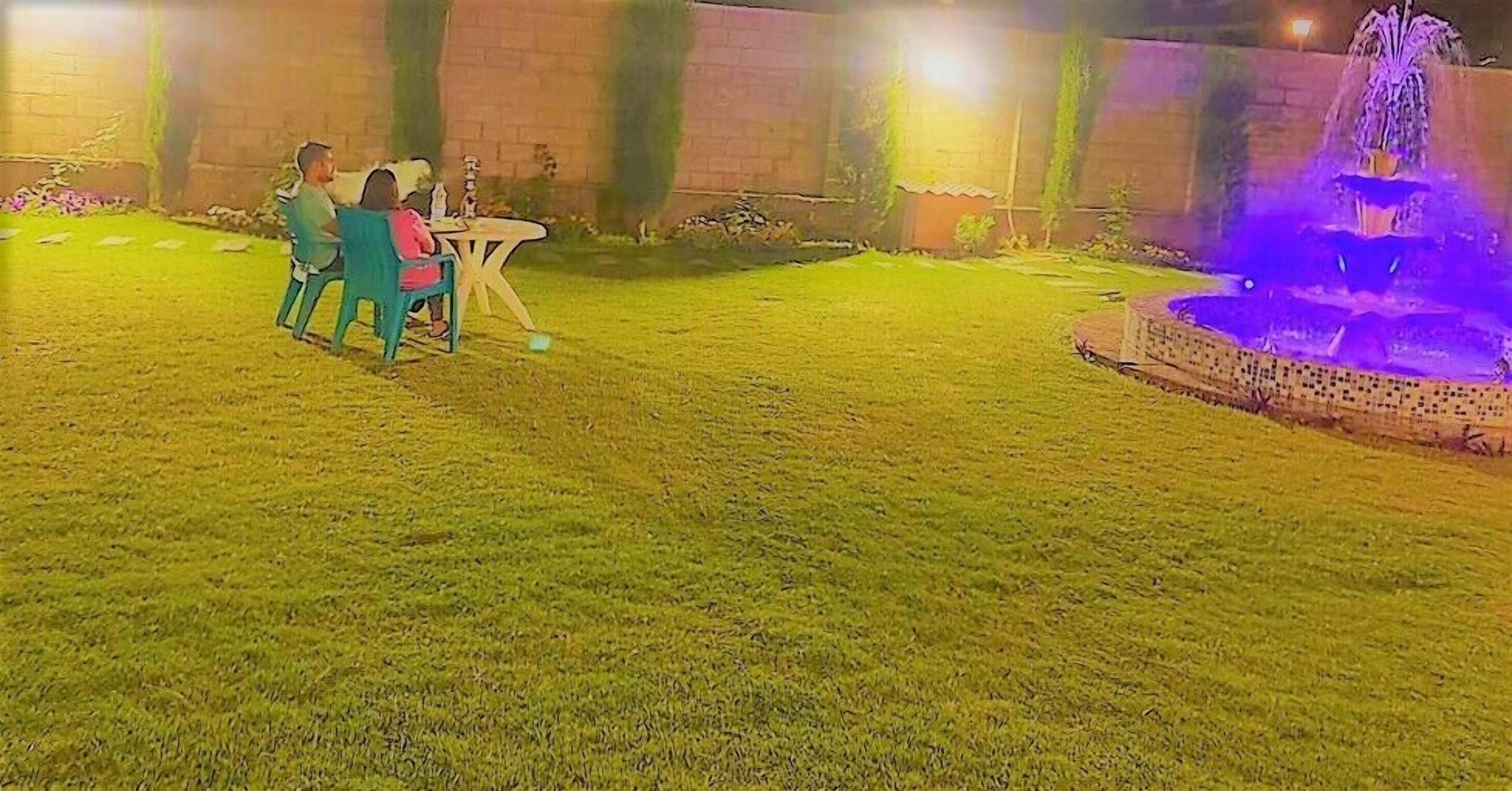 An outdoor area with a fountain, a table, and chairs.