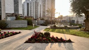 A residential area with modern high-rise buildings, a paved walkway, and landscaped gardens. - MAMAD Deluxe Apt & Terrace with City Overview by FeelHome (Holon)