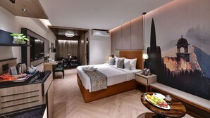 Una habitación de hotel moderna con una cama grande, una zona de comedor, un televisor y un mural de un castillo.