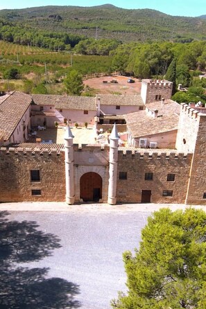 Un bâtiment historique doté d’une cour intérieure, de murs en pierre et d’une porte.