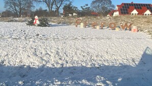 A snowy landscape with a large sign spelling "Flickr" and a snowman statue.
