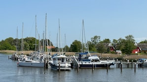 A marina with several sailboats docked at wooden piers.