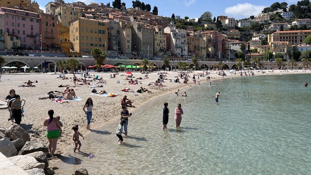 A beach with clear water, people sunbathing, and buildings in the background. - LE PAMELA facing the sea, exceptional view, private garden, private parking (Menton)