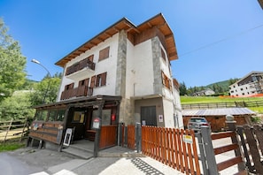 Un bâtiment à deux étages doté d’un balcon en bois, d’une entrée bien visible et d’une allée bordée d’une clôture.