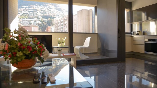 Une cuisine moderne avec une grande fenêtre, une chaise blanche et une plante en pot posée sur une table.