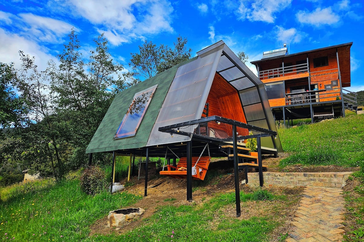 Una casa moderna con techo inclinado y un amplio ventanal.
