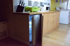 A compact kitchen with a built-in dishwasher, a microwave, and a sink.