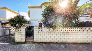 Uma entrada murada com parede de tijolos e detalhes em metal decorativo.
