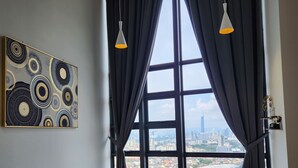 Una habitación moderna con una mesa de comedor, sillas, un ventilador de techo y un gran ventanal con cortinas.