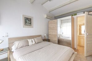 Une chambre à coucher avec un grand lit, une table de chevet, une lampe et un miroir.