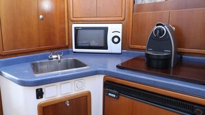 Cocina compacta con lavaplatos, microondas y cafetera.