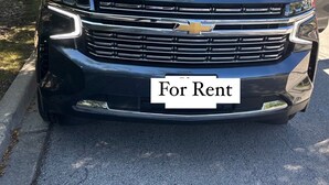 Musta Chevrolet-merkkinen katumaasturi on pysäköity kadulle, ja taustalla näkyy puita.