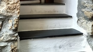 Una escalera con paredes de piedra y una puerta de madera.