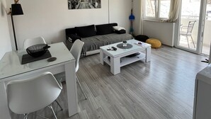 Una sala de estar moderna con sofá, mesa de centro y comedor.