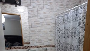 Un baño con lavamanos, inodoro y cortina de ducha.