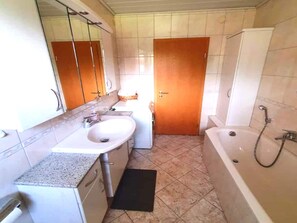 Une salle de bain avec un lavabo, un miroir et une douche.