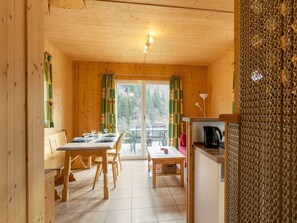 Cozy cabin with a dining area, kitchenette, and forest views.