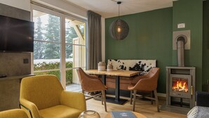 Un salon confortable avec une cheminée, une table à manger avec des chaises et un téléviseur.