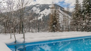 Une piscine avec une chaîne de montagnes enneigées en arrière-plan.