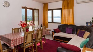 Una habitación con una mesa de comedor, sillas, un sofá y vistas al exterior.