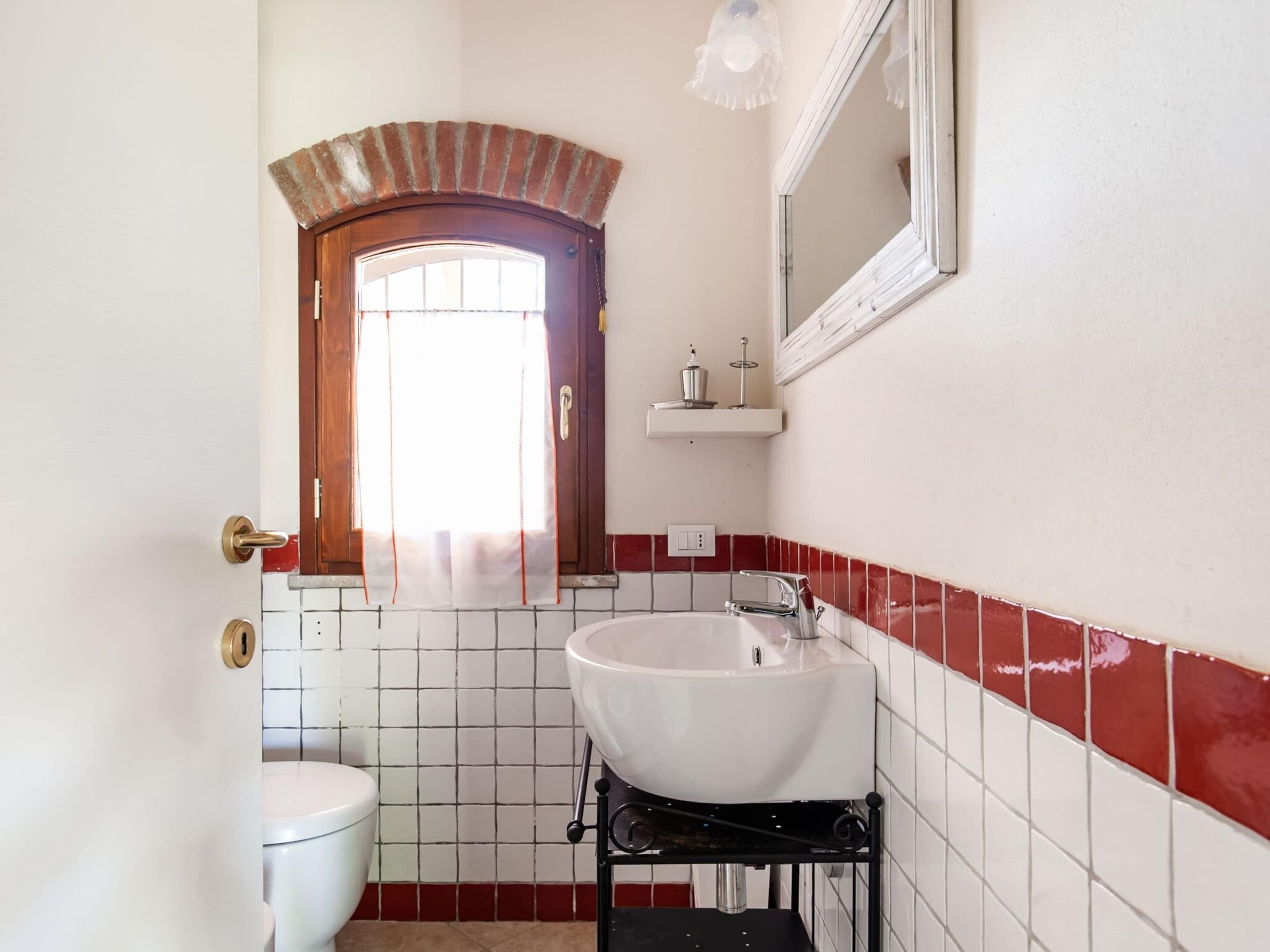 A bathroom with a white sink, a toilet, and a mirror above the sink.