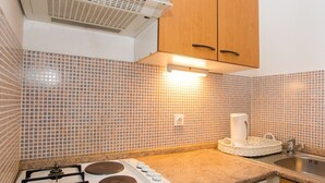 Uma cozinha com fogão a gás, pia e armários de madeira.