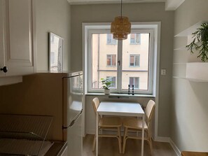 Una cocina con ventana, una mesa y sillas.